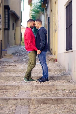 Two men having romantic moment in European city, vertical