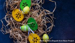 Easter decorations scattered in straw on navy table 0gXLol
