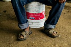 adult man resting on bucket
