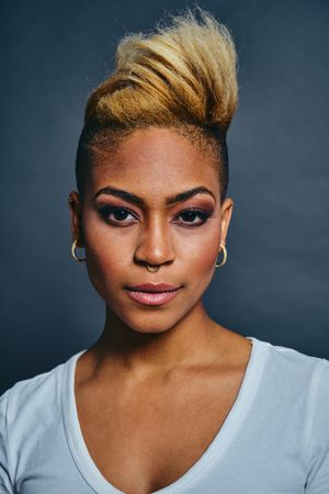 Portrait of Black woman with short blonde hair against gray background