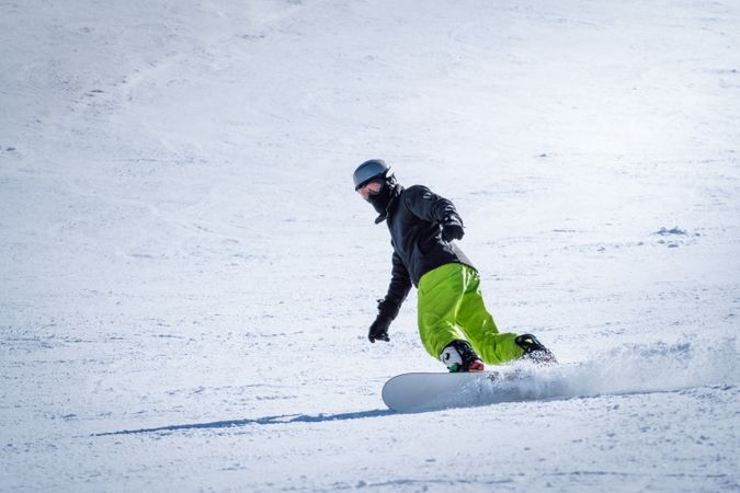Unrecognizable snowboarder riding on slope