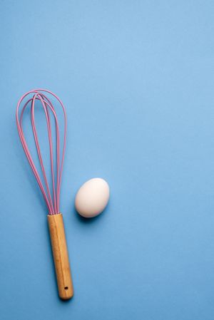 Kitchen whisk and a single egg