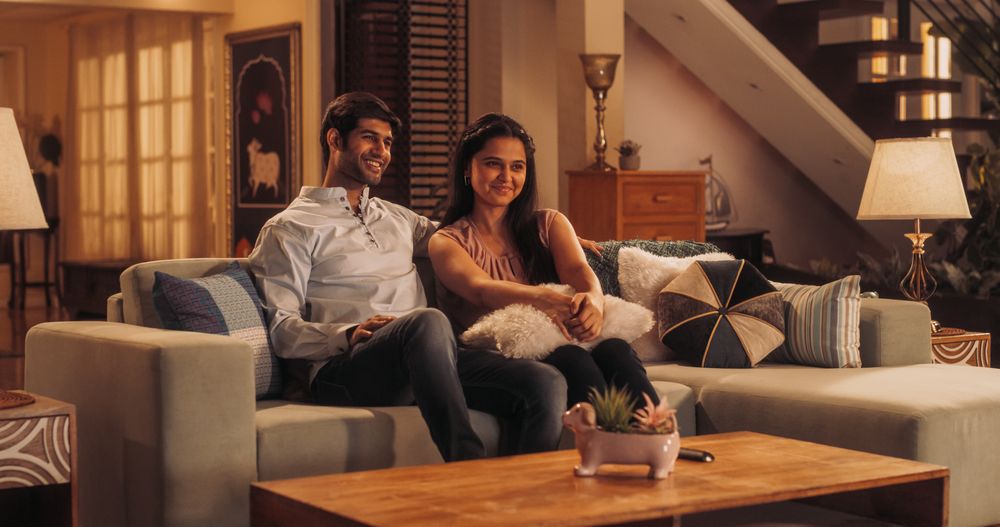 Movie Night: Young Couple Relaxing on the Couch, Watching Exciting Movie on TV. Girlfriend and Boyfriend Embrace