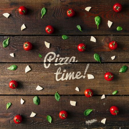 Basil, tomatoes, and cheese on wooden background with “Pizza time!” text