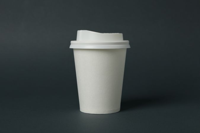 paper cup on light dark background, space for text