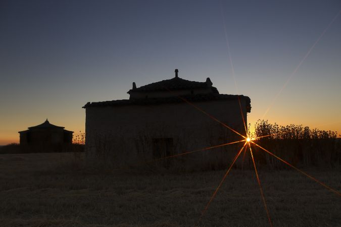 Aged house in rural countryside under starry sky
