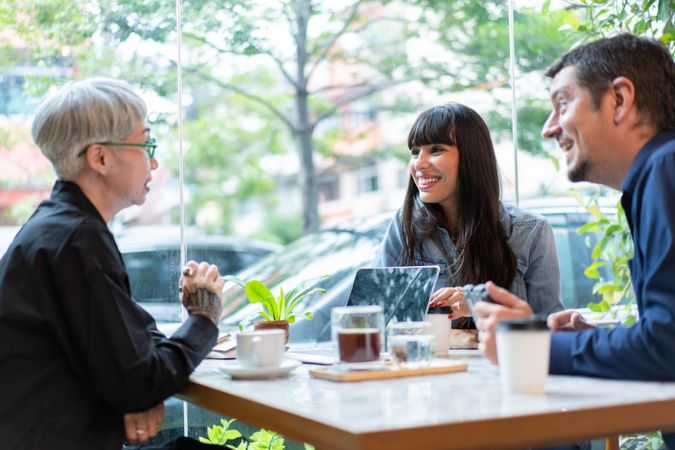 Business sales team have meeting with mature Asian woman in the coffee shop