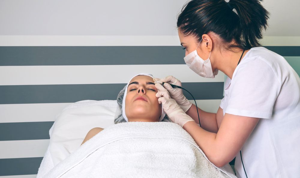 Woman receiving treatment on face in clinical center