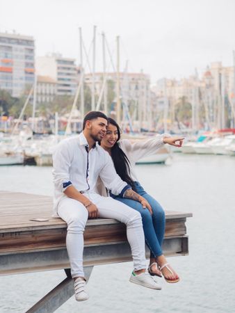 Man and woman sitting on dock with feet