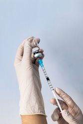 Hand holding syringe with vaccine. Vaccination concept. Covid-19