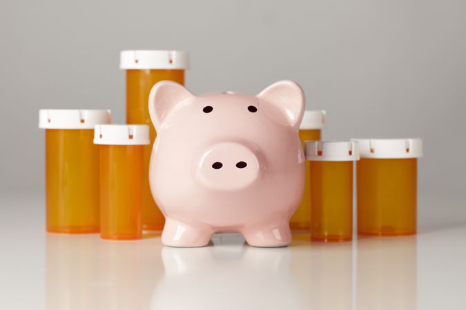 Piggy Bank In Front of Several Medicine Bottles