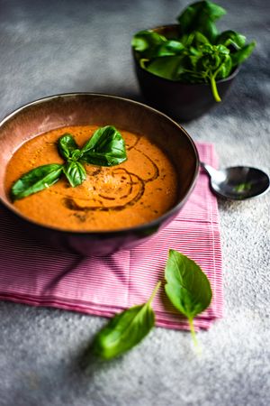 Tomato soup with oil garnish and basil leaves