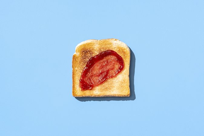 Toast bread with strawberry jam isolated on a blue background