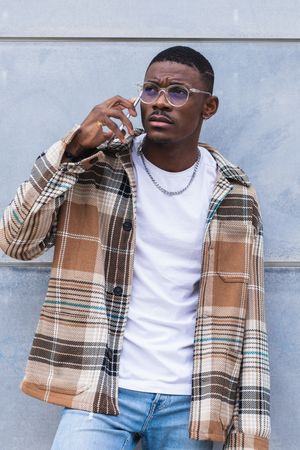 Stylish Black male using smartphone on street