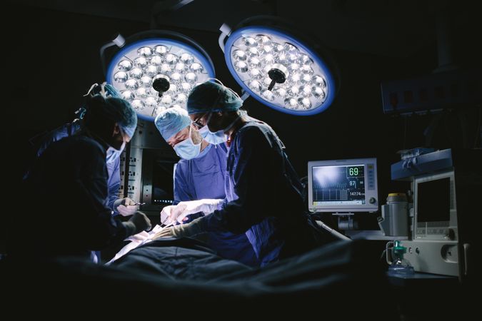 Team of surgeons doing surgery in hospital operating room