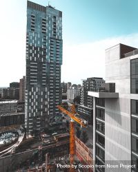 Yellow crane near high-rise building in city 5r1JM0