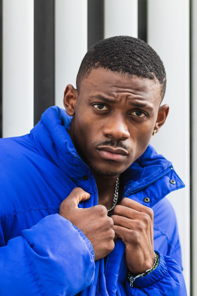 Black stylish man in warm jacket on street