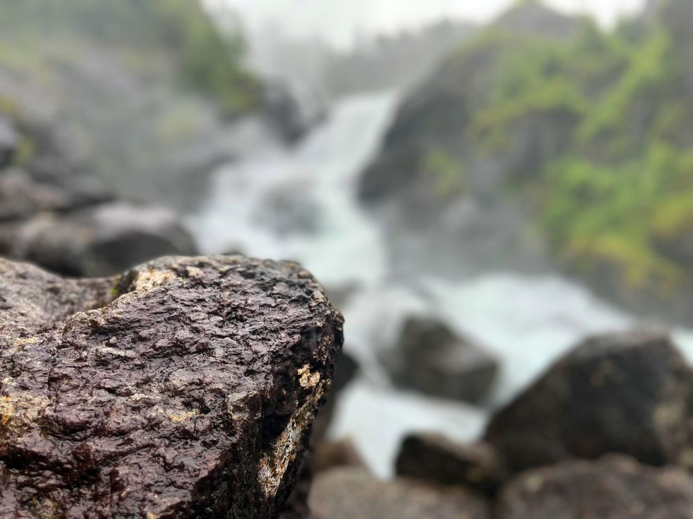 Rocks in foreground of Odda Trail rapids in Norway