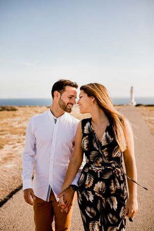 Happy lovers walking on path from sea