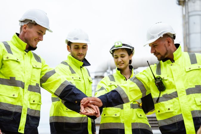 Group of engineer stacking hand in unity, symbolizing teamwork and collaboration