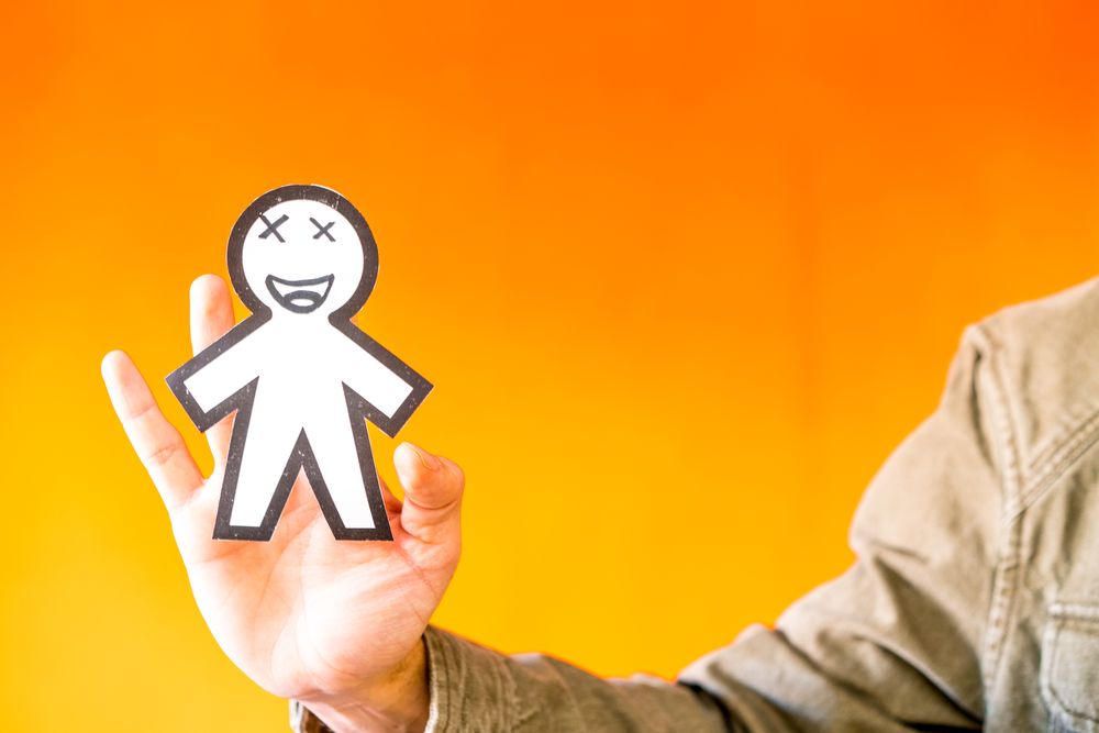 Smiling man holding funny paper toy
