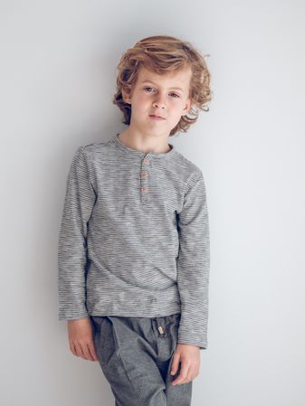 Charming boy standing near wall