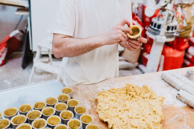 Crop cook decorating pastry with nuts