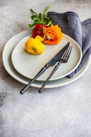 Rustic table setting with ranunculus flowers on grey plate