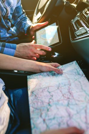 Couple comparing paper map and a gps navigator