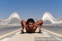 Man doing push up on bridge during daytime beB1p0