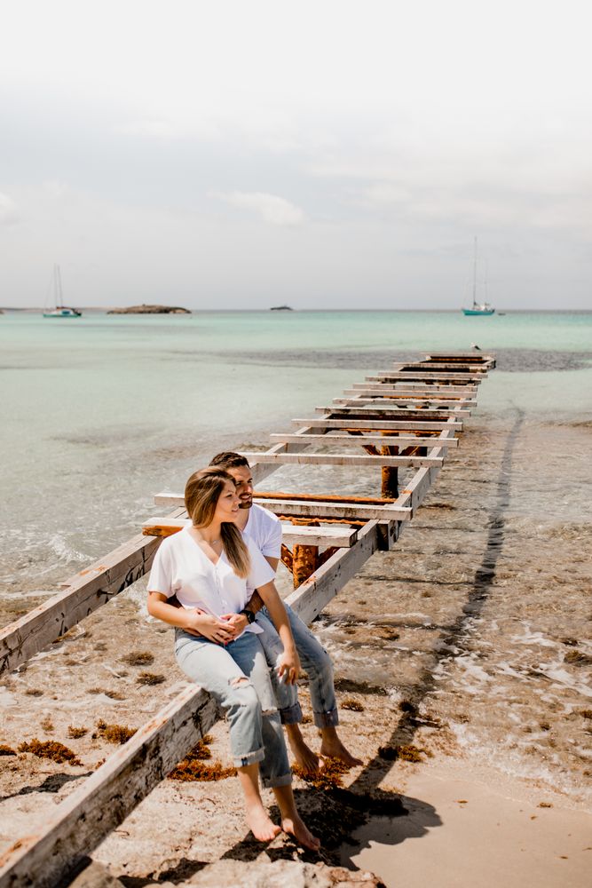 Glad lovers cuddling on destroyed pier on seashore