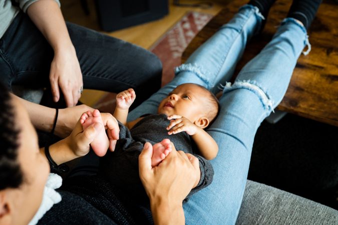 Cute new born baby in mother’s lap as she wears jeans