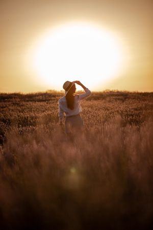 Anonymous woman walking in lavender field