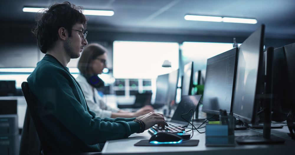 Portrait of a Thoughtful Engineer Working on Desktop Computer in a Technological Office Environment.