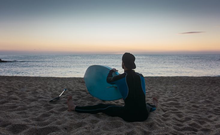 Man practicing paddle surfing with neoprene in a sunrise