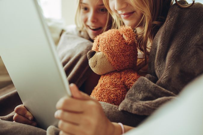 Cropped shot of two girls looking at a tablet pc sitting at home