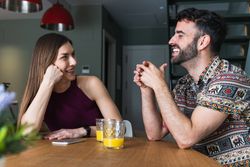 Content couple chatting and having orange juice in kitchen