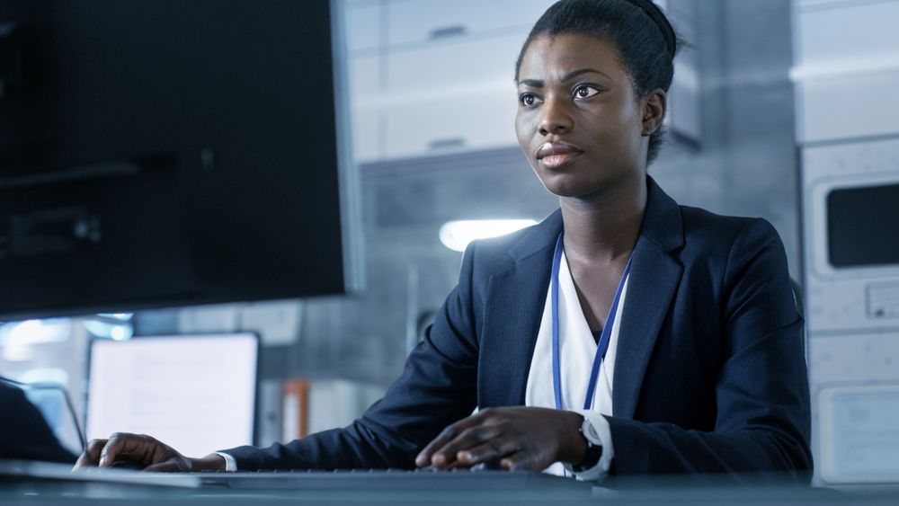 Female Scientist Working on a Computer with Her Colleagues at Research Center.