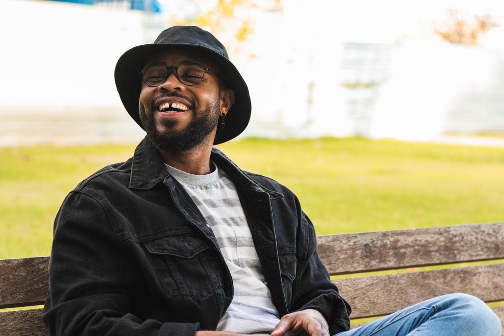 Trendy Black man sitting on bench