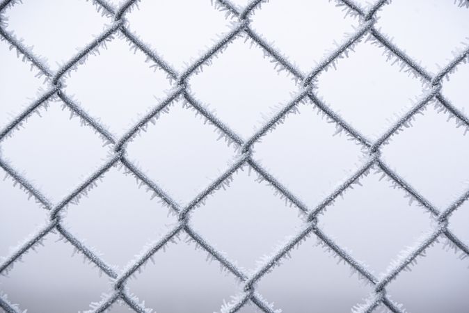 Metal wire fence covered with snow