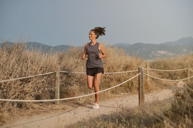 Cheerful woman running in countryside