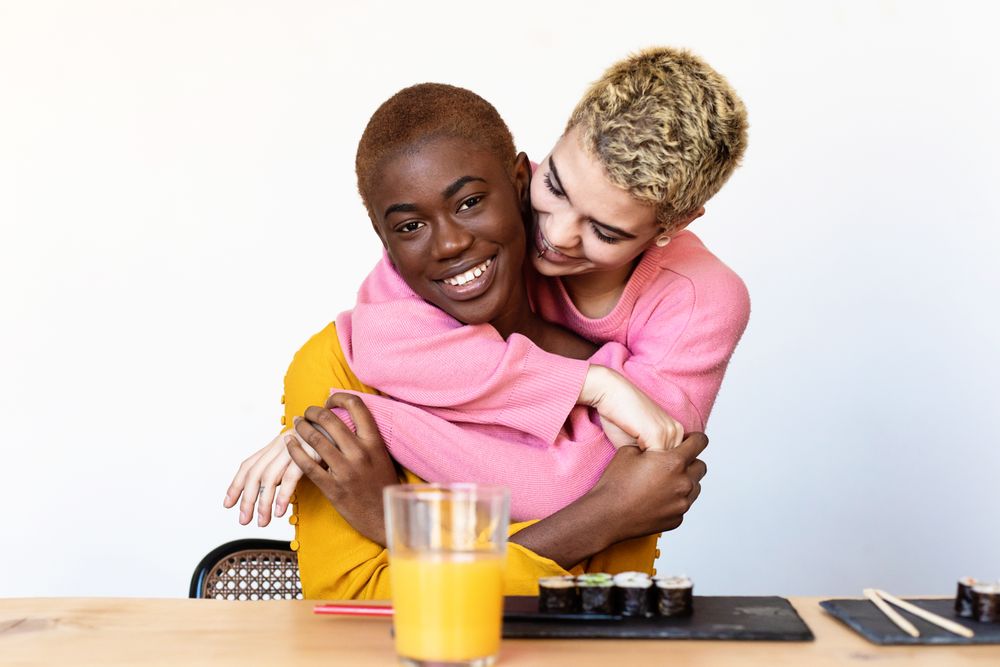 Female couple sharing sushi at home