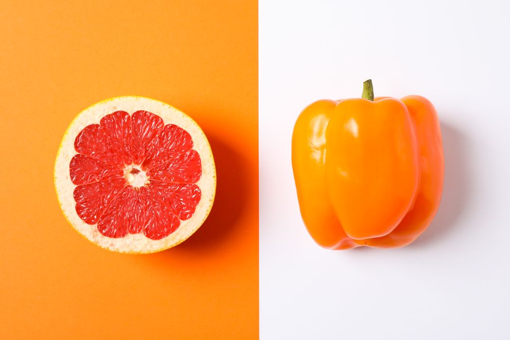 Grapefruit and pepper on two tone background, space for text