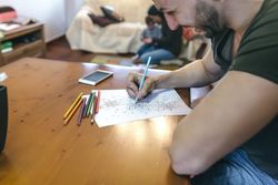 Young man coloring mandalas
