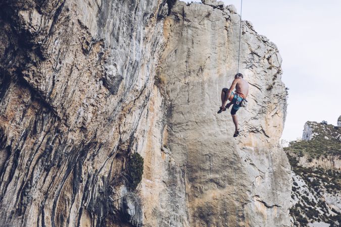 Anonymous climber handing on cliff