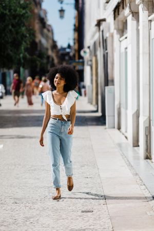 Young Black female walking down street