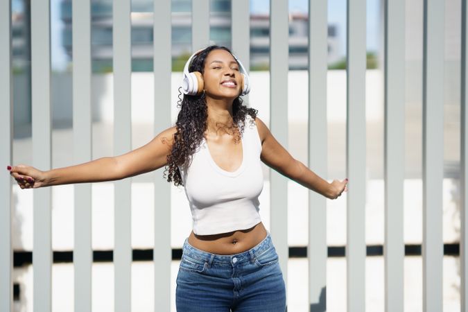 A Joyful Young Woman is Happily Enjoying Music with Headphones While Outdoors in Nature