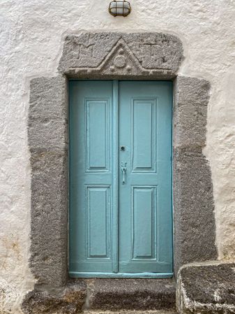 Patmian blue door with stone frame