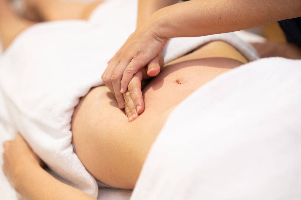 Physiotherapist working on patient’s stomach