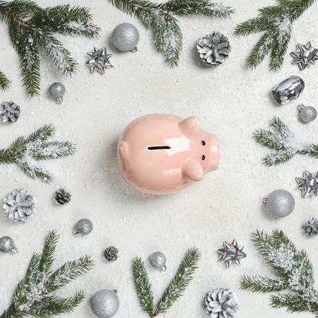 Piggy bank, fir branches and Christmas decorations on cream background, top view